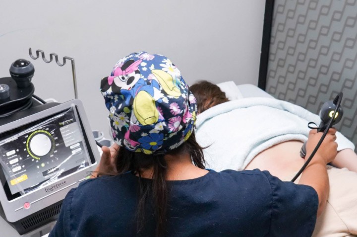 Licenciada de Effecta aplicando tratamiento en la espalda de un paciente